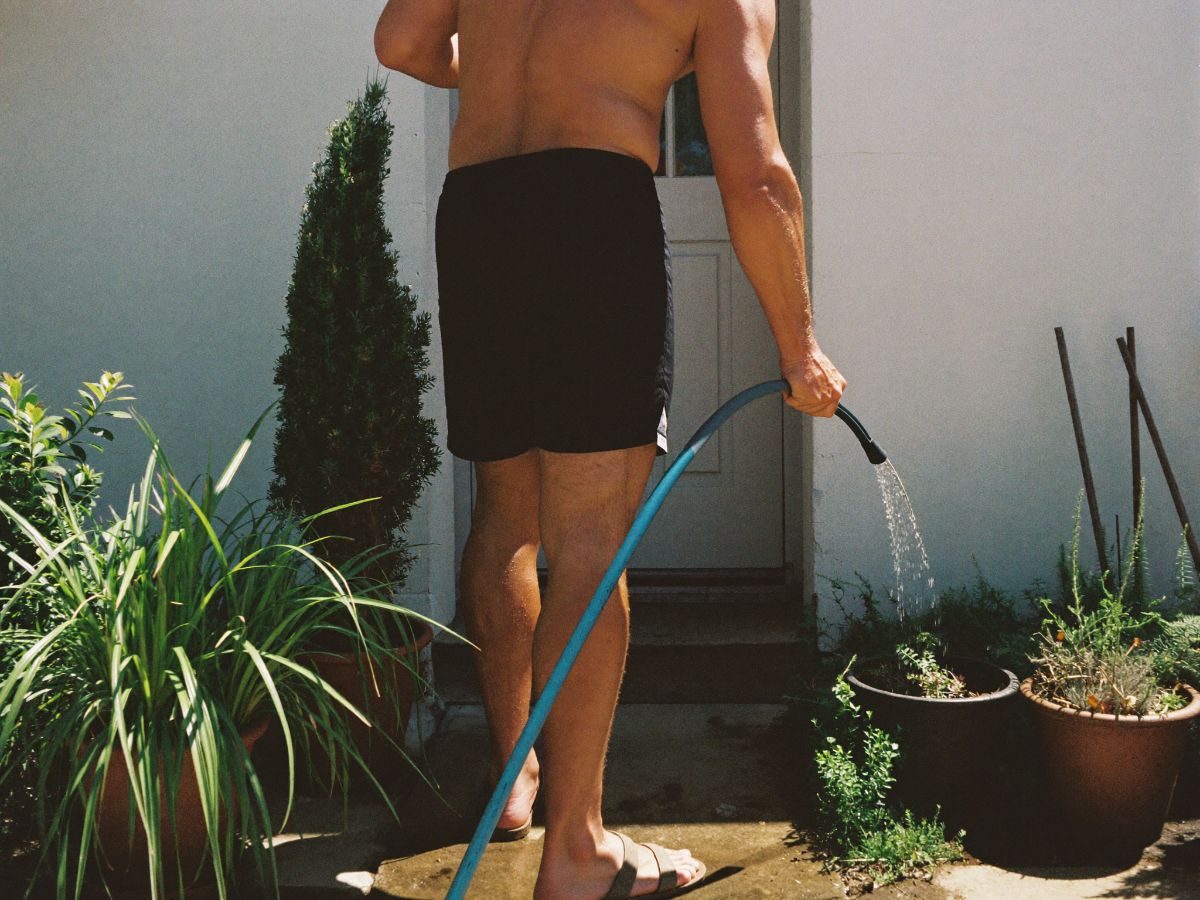 Someone watering front-yard plants